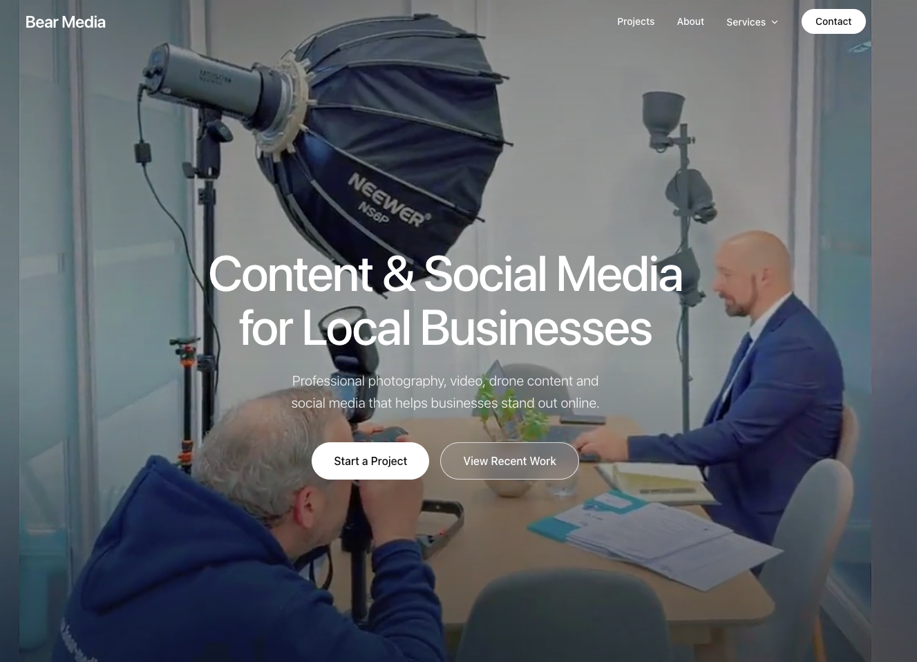 Bear Media homepage hero — Garry photographing a business shoot under studio lighting